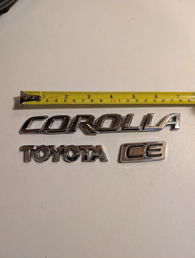 OEM 💥2009 2010 2011 2012 2013 TOYOTA COROLLA CE REAR TRUNK DECK LID EMBLEMS - Image 1 of 1