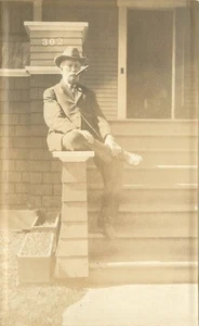 RPPC Postkarte Mann sitzt auf Stufen des Hauses 302 raucht Zigarre - Bild 1 von 2