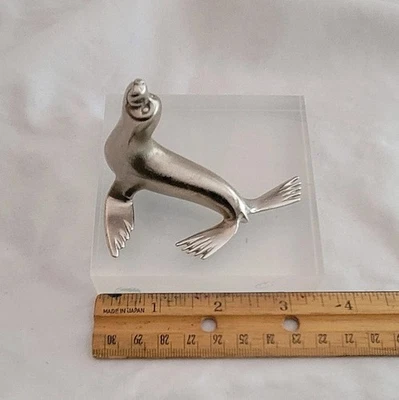 Escultura de león marino de metal con base acrílica  Foto 1 de 2