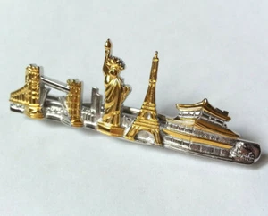 PINCE A CRAVATE vintage MONUMENTS CELEBRES VILLES DU MONDE doré et argenté - Imagen 1 de 4