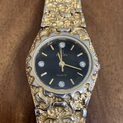 Reloj analógico de cuarzo pepita tono dorado Elgin para mujer 25 mm esfera negra funcionando Foto 1 de 4