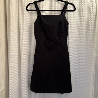 Mini vestido negro con delantal atado y espalda COS Foto 1 de 4