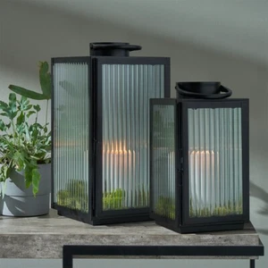 Juego de 2 linternas de vidrio de metal negro y velas acanaladas - Imagen 1 de 14