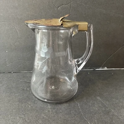 Jarra de jarabe de vidrio grabado vintage con tapa metálica con bisagras. Foto 1 de 4