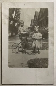 niño en triciclo con una chica más joven compañera RPPC CYKO - Imagen 1 de 2