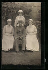 Foto-AK Soldat mit drei Krankenschwestern im Lazaretthof, Rotes Kreuz 1915 