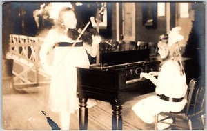 Girls Music Practice Playing Piano And Violin Real Photo RPPC Postcard - Picture 1 of 2