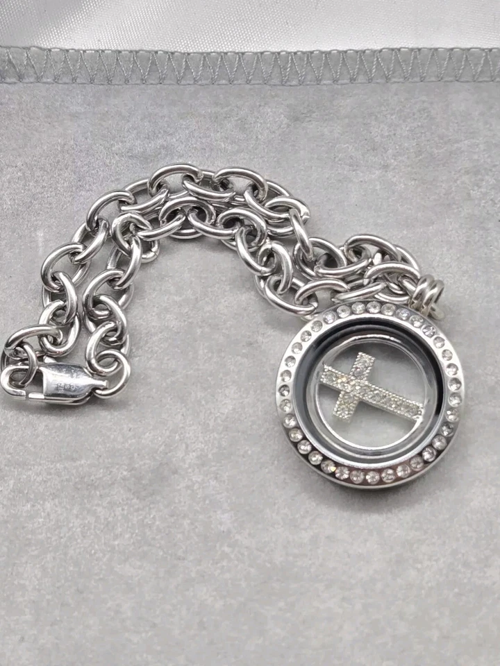 Pulsera Ibb de acero inoxidable con dije de cruz flotante pedrería blanca... Foto 1 de 4