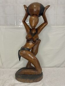 Statua in legno. Donna nuda alla ricerca di acqua