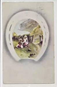 Viel Glück Hufeisen Mädchen spielen auf Hof nahe Felsenstrand geteilter Rücken Gruß - Bild 1 von 2