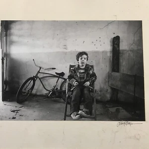 Photo Of A Young Boy Sitting On His Chair In Front Of His Bicycle - Picture 1 of 10
