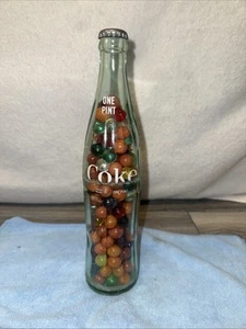 Eine Coca Cola Flasche gefüllt mit Murmeln - Bild 1 von 4