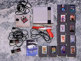 Nintendo NES with 12 games, 2 controllers, game pad, & zapper. Great condition!!