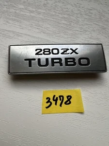 Placa de insignia con bisel turbo Datsun 280ZX 1979-1983 96948P9000 FABRICANTE DE EQUIPOS ORIGINALES - Imagen 1 de 7