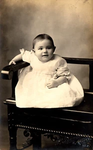 Postkarte RPPC fröhliches Säugling Baby Mädchen im Kleid auf Stuhl gestempelt Hooper Nebraska - Bild 1 von 2