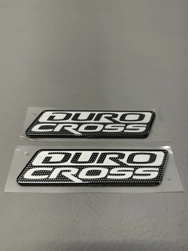 Mitsubishi Raider Duro 2006-2009 emblema de puerta lateral cruzada logotipo insignia usado conjunto OEM Foto 1 de 4