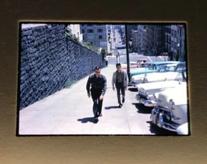 Vehículos de los años 50 estacionados de San Francisco para hombres caminando cuesta arriba años 60’s - Imagen 1 de 3