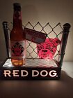 Panneau de bière vintage Red Dog protégé par une clôture allumer