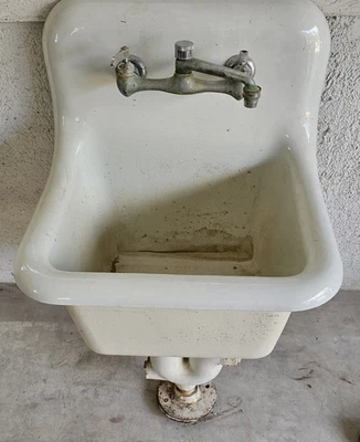 Fregadero de pedestal vintage de hierro fundido montado en la pared con grifo original. Foto 1 de 4