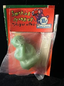 Juguete vintage de tienda de centavos años 60 VERDE mono fumador cigarrillos sopla anillos de humo C - Imagen 1 de 3