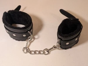 Puños de muñeca forrados peludos de cuero sintético negro con cadena - usados, signos de desgaste - Imagen 1 de 4