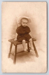 Postcard Unidentified RPPC Toddler Child Sitting On Stool Frowning Posing Photo - Picture 1 of 2