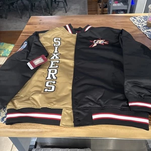 CHAQUETA DE SATÉN PARA HOMBRE MITCHELL AND NESS PHILADELPHIA 76ERS SIXERS NEGRA/DORADA L NUEVA CON ETIQUETAS - Imagen 1 de 12