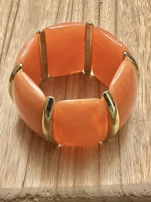 Brazalete elástico grueso acrílico naranja segmentos tono dorado 7”. Foto 1 de 2