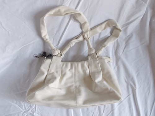 OFF WHITE VINTAGE 1980s OFF WHITE FAUX LEATHER HANDBAG WITH DECORATIVE CHARM BRACELET