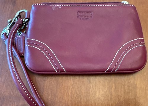 Portafoglio Coach in pelle rosso bordeaux con zip e cinturino ed etichetta