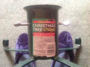 green metal christmas tree stand. for real tree between 5 and 7 ft. used good