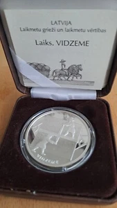 Letonia - Moneda de plata de 1 Lats Vidzeme carruaje de caballos; arado 2004 y proof - Imagen 1 de 5