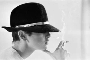 Model Twiggy posing in the studio wearing a black hat and smoking - Old Photo - Bild 1 von 1