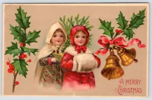 1910's MERRY CHRISTMAS GIRLS WINTER COATS MUFF BELLS HOLLY EMBOSSED POSTCARD - Picture 1 of 2