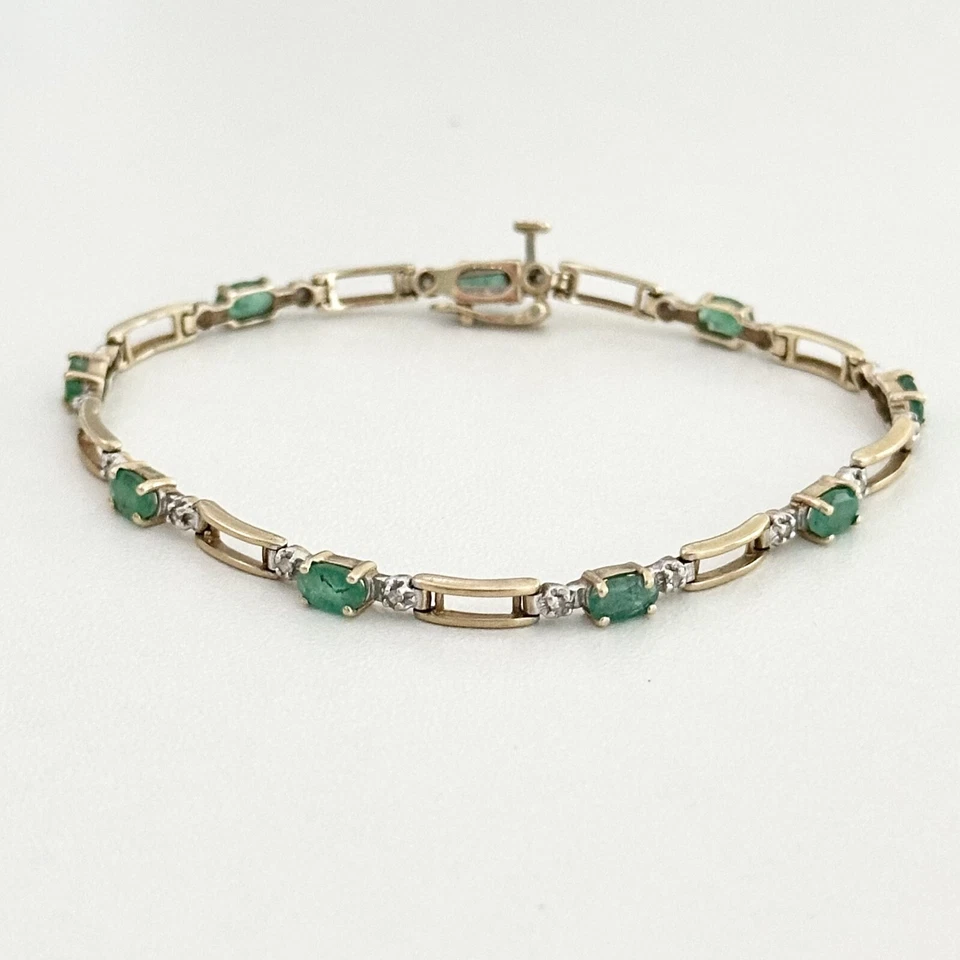 Brazalete de eslabones de cadena abierta de tenis de diamantes y esmeraldas de oro amarillo de 10 quilates Foto 1 de 4