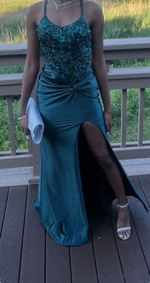 Este vestido es un glamoroso vestido hasta el suelo en una tela satinada verde cazador profundo. Foto 1 de 3