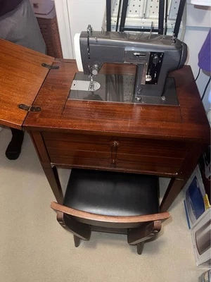 Antigua máquina de coser con silla e hilos Foto 1 de 4