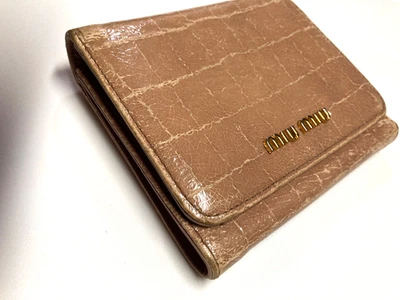 CARTERA COMPACTA DE CUERO CON LOGOTIPO DE METAL VINTAGE MIU MIU PATRÓN COCODRILO BEIGE ITALIA Foto 1 de 4