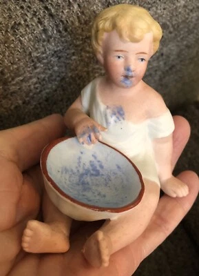 German Bisque Dirty Piano Baby Playing with Blue Paint in Bowl - Image 1 of 4
