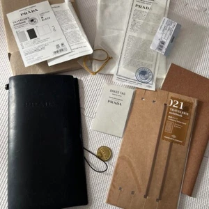 Prada Reisenotizbuch normale Größe Lederabdeckung schwarz mit Messingetikett gebraucht - Bild 1 von 5