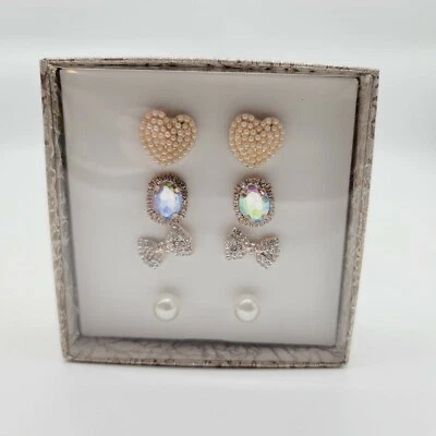 Cuatro juegos de aretes con arco de perlas en forma de corazón Foto 1 de 4