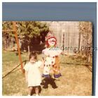 FOUND COLOR PHOTO F_8075 GIRL IN DRESS BY CLOWN PINATA HANGING