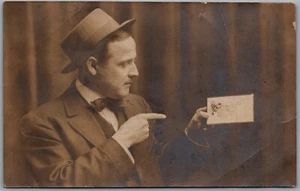 RPPC c1910s Man in Hat and Suit Holding a Postcard Real Photo - Picture 1 of 2
