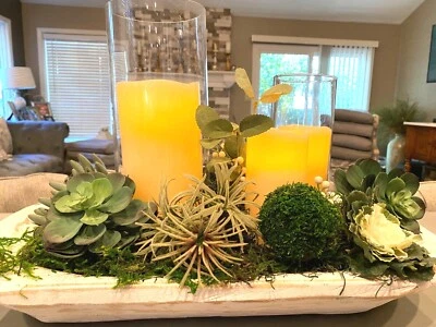 Centro de mesa suculento adornado con 2 candelabros de cristal y velas. Foto 1 de 3