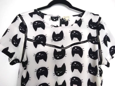 Blusa blanca talla M con caras de gato negras y detalles de crochet de Lily White. Excelente Foto 1 de 4