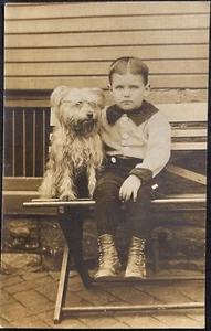 ECHTFOTO-POSTKARTE RPPC ~ KLEINER JUNGE SITZT DRAUSSEN AUF BANK mit WEISSER TERRIER HUND - Bild 1 von 3