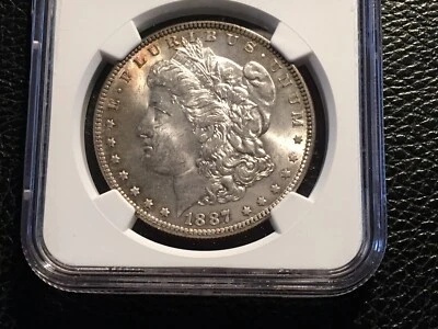 1887 Morgan Dollar NGC 63 Uncirculated Some Nice Gold Toning  - Image 1 of 4