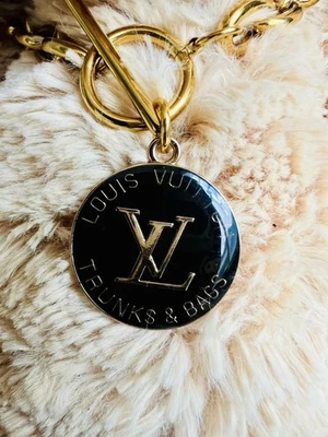 Auténticos baúles y bolsos Louis Vuitton negros con dije en cadena sin marca Foto 1 de 4