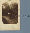 REAL PHOTO RPPC A+1908 MAN IN SUIT POSED BY BUSHES