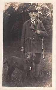 UN CAZADOR Y SU PERRO, RIFLE Y BINOCULARES: NEUKOLLN, ALEMANIA: RPPC - Imagen 1 de 2